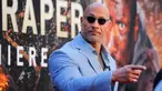 Aktor AS Dwayne Johnson tiba menghadiri pemutaran perdana film "Skyscraper" di New York City, AS (10/7). Dwayne Johnson tampil keren dengan kaca mata hitam dan setelan kemeja berwarna abu-abu. (AFP Photo/Kena Betancur)