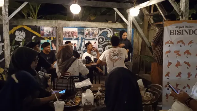 Komunitas inklusi sedang mempratikkan bahasa isyarat di salah satu sudut kafe yang menjadi lokasi pameran (Liputan6.com/Rino Abonita)