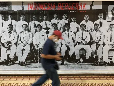 Petugas berjalan melewati karya dalam Pameran Fotografi dan Grafis bertajuk “Indonesia Bergerak: 1900-1942“ di Galeri Foto Jurnalistik Antara, Pasar Baru, Jakarta, Selasa (8/9/2020). Pameran tersebut memperlihatkan rekam jejak intelektual semasa pergerakan nasional. (Liputan6.com/Immanuel Antonius)