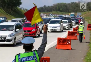 Petugas kepolisian mengatur lalu lintas di jalur arah Jakarta Tol Cipali, Jawa Barat, Kamis (29/6). Sejumlah kepolisian disiagakan untuk mengatur lalu lintas di Tol Cipali yang semakin padat oleh pemudik arus balik. (Liputan6.com/Faizal Fanani)