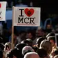 Sejumlah orang membawa poster 'I Love MCR' di pusat kota Manchester, sehari setelah ledakan bom saat konser Ariana Grande, Selasa (23/5). Mereka menggelar doa bersama untuk korban serangan bom yang menewaskan 22 orang (AP Photo/Kirsty Wigglesworth)