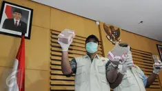 Petugas menunjukkan barang bukti hasil OTT terkait dugaan suap pengurusan perkara Saipul Jamil di KPK, Jakarta, Kamis (16/6). Kakak Saipul Jamil diketahui melakukan suap kepada Panitera PN Jakarta Utara dengan uang Rp 250 juta. (Liputan6.com/Helmi Afandi)