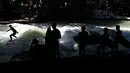 Sejumlah peselancar melihat rekannya menaklukkan ombak buatan saat bermain surfing di sungai 'Eisbach' di taman English Garden di Munich, Jerman (24/6/2019). Sungai Eisbach merupakan salah satu tempat berselancar sungai yang paling populer di Munich. (AP Photo/Matthias Schrader)