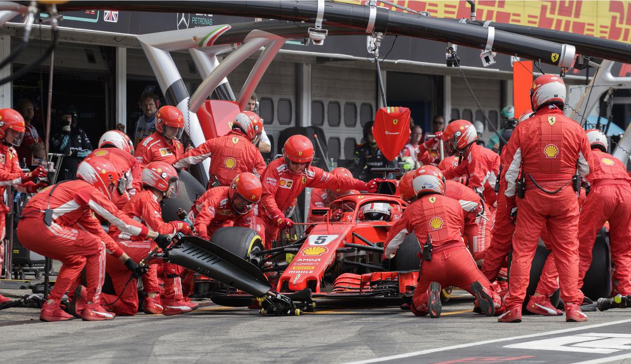 Sebastian Vettel saat menggati ban di pit stop pada balapan F1 Grand Prix di Hockenheim racing circuit, Jerman, (22/7/2018). Vettel kehilangan kendali saat perubahan cuaca dan menabrak pembatas. (AFP/POOL/Valdrin Xhemaj)