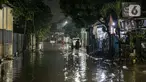 Warga melintas di genangan banjir di kawasan Mampang Prapatan, Jakarta, Sabtu (13/11/2021). Intensitas hujan yang tinggi sejak sore di Jakarta membuat kawasan permukiman di Mampang Prapatan tergenang banjir dengan tinggi sebetis orang dewasa. (Liputan6.com/Faizal Fanani)