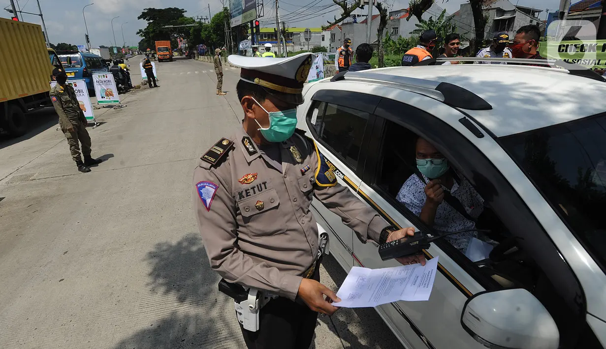 Polantas Polres Bogor memeriksa surat domisili pengemudi mobil  yang melintasi Pos Pengawasan Larangan Mudik di Cigombong, Bogor, Rabu (29/4/2020). Polres Bogor terus melakukan penyekatan  mencegat pemudik sekaligus PSBB mengantsipasi penyebaran virus Covid-19. (merdeka.com/Arie Basuki)