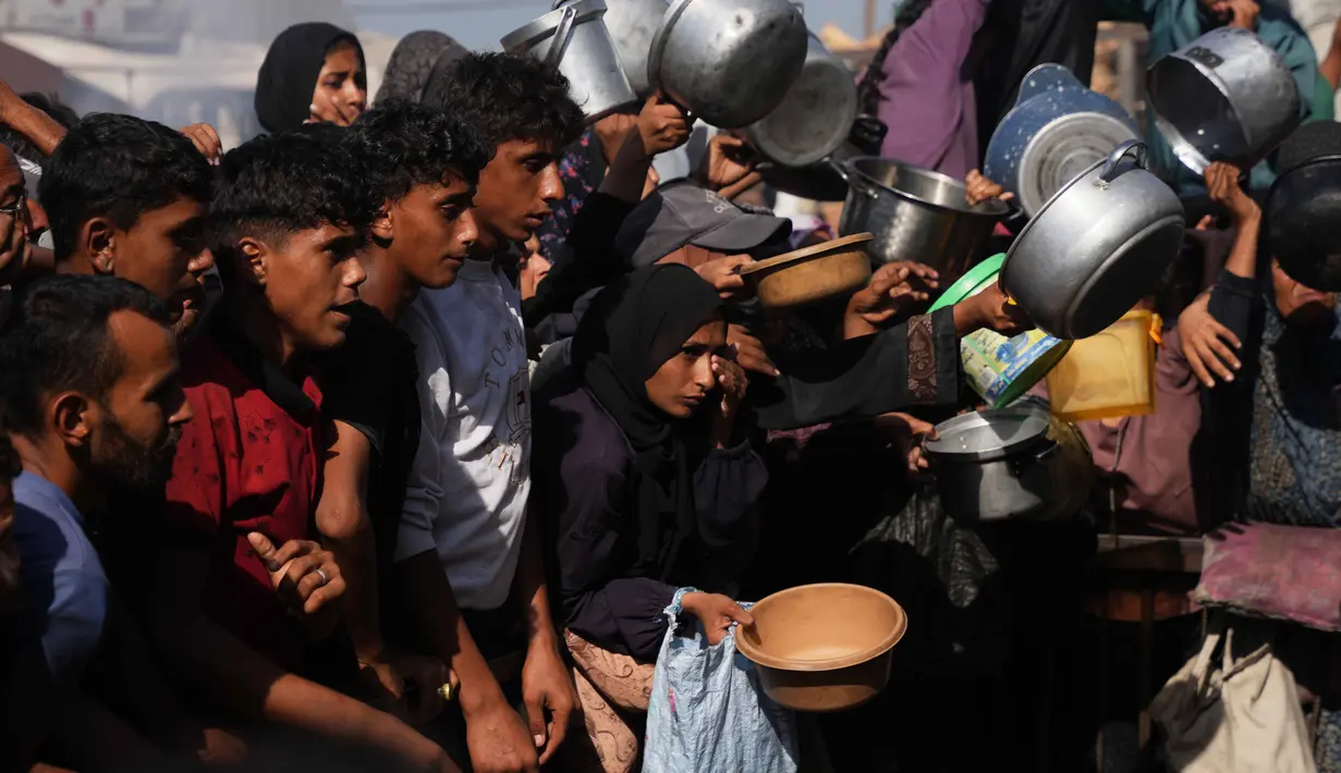Warga Palestina menunggu bantuan gula dan beras di dapur umum di Khan Younis, Jalur Gaza selatan, Jumat, 31 Oktober 2025. Mereka datang dengan membawa panci dan piring kosong serta harapan mendapat bantuan makanan. (AP Photo/Abdel Kareem Hana)