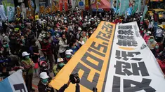 Demonstran mengunakan masker membawa spanduk raksasa saat unjuk rasa menuntut pemerintah Taiwan dalam pengurangan polusi udara di Taipei (26/12). Ratusan warga berbaris di jalan-jalan memprotes kebijakan energi pemerintah. (AFP PHOTO/Sam Yeh)
