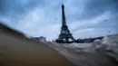 Menara Eiffel terlihat saat sungai Seine di Paris meluap, Prancis (7/1). Sungai Seine tidak mampu menampung debit air setelah hujan terjadi terus-menerus sehingga meluap sejajar dengan tinggi jalan. (AFP Photo/Olivier Morin)