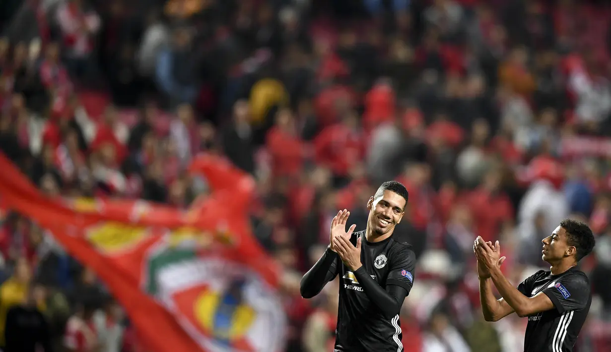 Pemain Manchester United, Chris Smalling dan Jesse Lingard merayakan kemenangan atas Benfica pada laga Liga Champions di Stadion Luz, Kamis (19/10/2017). Manchester United menang 1-0 atas Benfica. (AFP/Patricia De Melo Moreira)