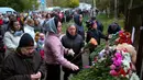 <p>Orang-orang berkumpul untuk meletakkan bunga, mainan, dan menyalakan lilin untuk mengenang para korban penembakan di Sekolah No. 88, Izhevsk, Rusia, Senin (26/9/2022). Sebanyak 982 siswa dan 80 guru dari sekolah itu saat ini telah dievakuasi. (AP Photo/Sergei Kuznetsov)</p>