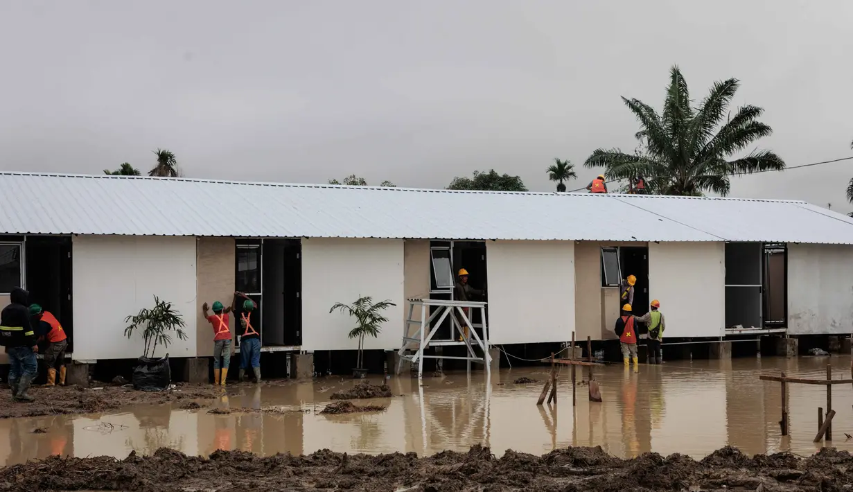 Hunian sementara tersebut dirancang sebagai solusi tempat tinggal selama masa transisi pemulihan. Tampak dalam foto, unit-unit perumahan sementara yang dibangun oleh Danantara, Badan Pengelola Investasi (BPI) strategis Indonesia, sedang dibangun untuk warga yang dievakuasi akibat banjir bandang, seiring dengan berlanjutnya pembangunan di 14 lokasi di Aceh Tamiang, provinsi Aceh, pada Kamis 8 Januari 2026. (ADITYA AJI/AFP)