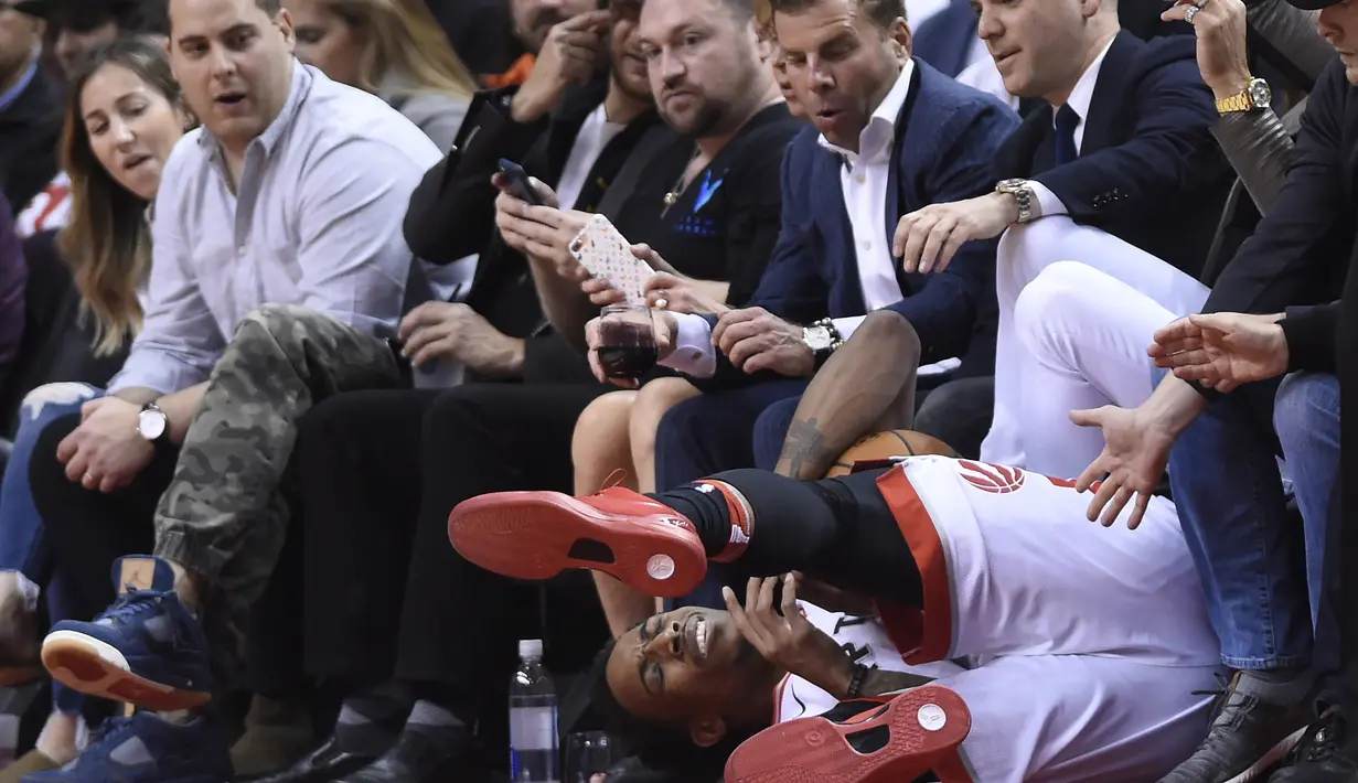 Pemain Raptors, DeMar DeRozan jatuh saat berebut bola dengan pemain Cavaliers pada laga NBA basketball playoffs Eastern Conference semifinal di Air Canada Centre, (1/2/2018). Cavaliers menang 113-112. (Nathan Denette/The Canadian Press via AP)