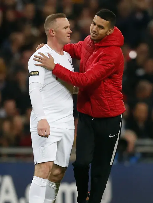 Seorang suporter menghampiri striker Inggris, Wayne Rooney selama pertandingan melawan Amerika Serikat (AS) di Stadion Wembley, Inggris (16/11). Rooney juga diberikan ban kapten dalam laga tersebut. (AFP Photo/Ian Kington)