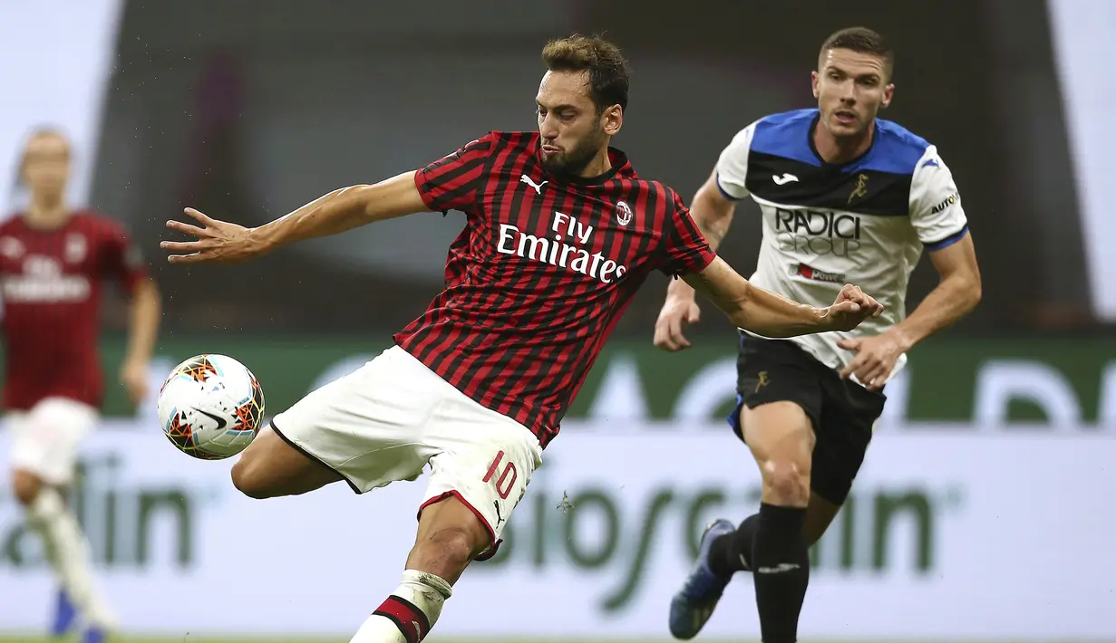 Pemain AC Milan Hakan Calhanoglu (tengah) bersiap melakukan tendangan saat menghadapi Atalanta pada pertandingan Serie A di Stadion San Siro, Milan, Italia, Jumat (24/7/2020). Pertandingan berakhir 1-1. (Spada/LaPresse via AP)