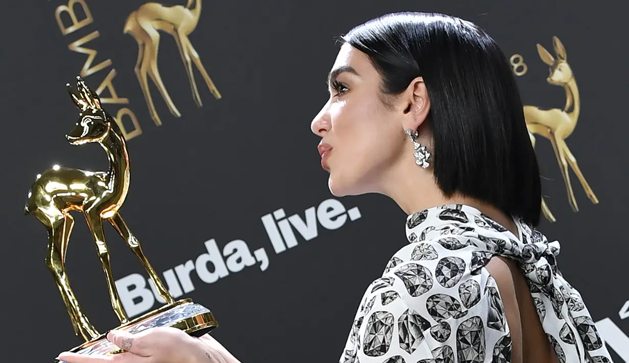 Penyanyi Inggris Dua Lipa berpose setelah menerima Penghargaan Bambi Awards ke-70 di Potsdamer Platz di Berlin (16/11). Dua Lipa meraih penghargaan kategori Music International di acara tersebut. (AFP Photo/Jens Kalaene)