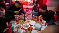 Sebuah keluarga merayakan Tahun Baru imlek dengan makan bersama di sebuah restoran (AP Photo/Ng Han Guan)