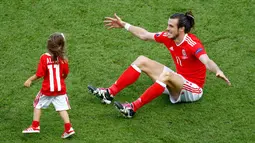 Gareth Bale bersama putrinya, Alba usai laga melawan Irlandia Utara dalam babak 16 besar Euro 2016 di Parc des Princes, Paris, Prancis, Minggu (26/6). (REUTERS/ Christian Hartmann)