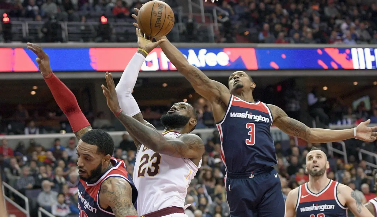 Pemain Cleveland Cavaliers, LeBron James (23) berusaha memasukan bola saat diadang para pemain Washington Wizards pada laga NBA basketball game di Capital One Arena, Washington, (17/12/2017). Cleveland menang 106-99. (AP/Nick Wass)