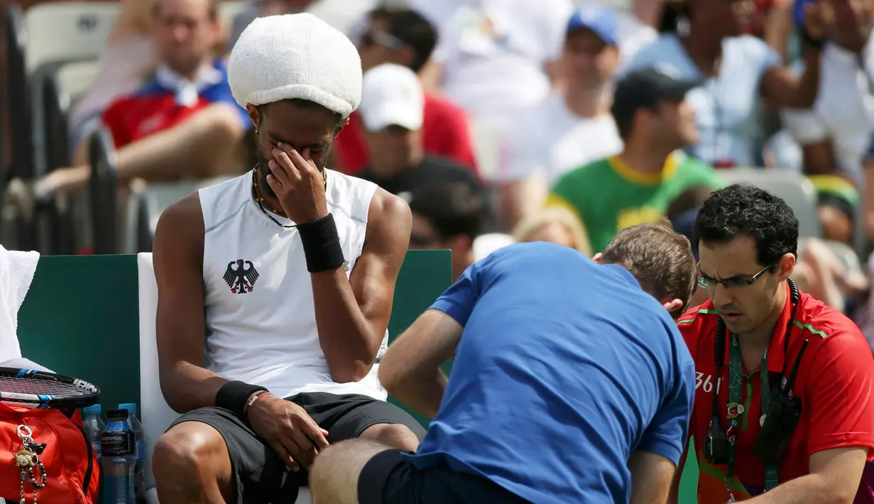 Tim Medis mengobati cidera pemain Tenis asal Jerman, Dustin Brown saat berlaga di Olimpiade Rio 2016 melawan Thomaz Bellucci asal Brasil, Brasil (7/8). (REUTERS) 