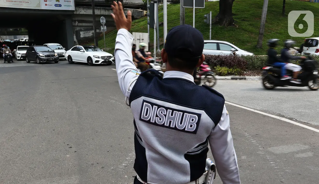 Petugas Dishub mengatur arus lalu lintas saat diberlakukan uji cobaSistem Satu Arah (SSA) di Jalan Margono Djoyohadikoesoemo, Jakarta, Sabtu (15/12/2019). Uji coba terkait adanya pembangunan stasiun LRT Jabodebek dan program Naturalisasi Kanal Banjir Barat. (Liputan6.com/Johan Tallo)