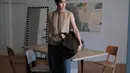 Thanapob Leeratanakachorn aktor Thailand mengenakan atasan tanpa lengan warna coklat dipadukan celana panjang abu-abu. Ia membawa Dior Normandie Tote bag hitam. [@thanapob_lee]