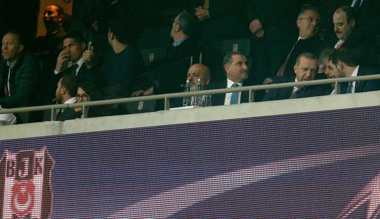 Presiden Turki Recep Tayyip Erdogan (ketiga kanan depan) menyaksikan pertandingan antara Besiktas JK melawan FC Porto pada Grup G Liga Champions di Vodafone Park di Istanbul (21/11). Besiktas dan Porto bermain imbang 1-1. (AP Photo / Lefteris Pitarakis)