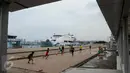 Seorang anak mencoba mengoper bola pada temannya saat bermain bola di pelataran Pelabuhan Kali Adem, Muara Angke, Jakarta, Rabu (4/1). Mereka memanfaatkan Kali Adem sebagai arena bermain selama mengisi masa liburan sekolah. (Liputan6.com/Gempur M Surya)