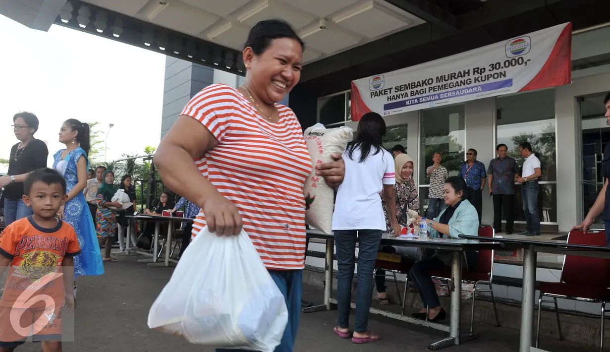Warga membawa Paket  Sembako Murah oleh PT Indosiar Visual Mandiri  di Studio 5 Indosiar, Jakarta, (10/6). Sebanyak 500 paket sembako murah seharga Rp 30 ribu per paket untuk 500 Kepala Keluarga (KK). (Liputan6.com/Johan Tallo)