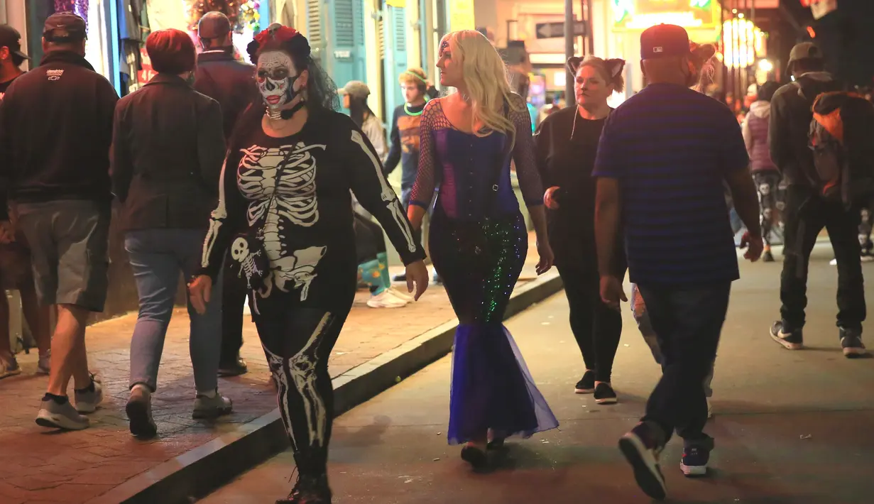 Warga yang mengenakan kostum Halloween melintasi jalan di New Orleans, Louisiana, Amerika Serikat, 31 Oktober 2020. Akibat pandemi COVID-19, perkumpulan warga dibatasi di New Orleans dan semua lokasi ditutup mulai pukul 23.00 waktu setempat pada Sabtu (31/10). (Xinhua/Lan Wei)