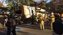Tim penyelamat berkumpul di dekat bus sekolah yang rusak setelah menabrak sebuah rumah di Chattanooga, Tennessee, Senin (21/11). Bus itu membawa sekitar 35 anak dari usia TK hingga kelas 5 sekolah dasar. (Courtesy of Chattanooga Fire Dept/via REUTERS)