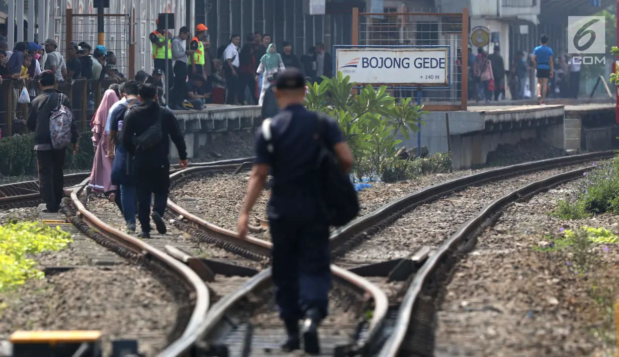 Sejumlah penumpang KRL Commuter Line terpaksa berjalan kaki menuju Stasiun Bojonggede, Bogor, Jawa Barat, Minggu (4/8/2019). Padamnya listrik di wilayah Jabodetabek mengakibatkan perjalanan KRL Commuter Line terhenti. (Liputan6.com/Helmi Fithriansyah)