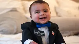 Wali Kota Kehormatan Whitehall Charlie McMillan tertawa di rumahnya di Whitehall, Texas, Amerika Serikat, Jumat (20/12/2019). Bayi imut tersebut ditunjuk sebagai wali kota melalui lelang dalam acara penggalangan dana Pemadam Kebakaran Sukarelawan Whitehall. (Mark Felix/AFP)
