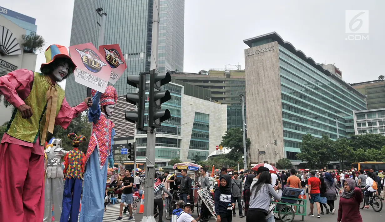 Badut menyosialisasikan sistem tilang Electronic Traffic Law Enforcement (ETLE) kepada pengunjung car free day (CFD) di Bundaran HI, Jakarta, Minggu (25/11). Sosialisasi ini untuk memperkenalkan sistem ETLE kepada masyarakat. (Merdeka.com/Iqbal Nugroho)