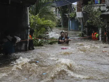 Warga berpegangan pada tali saat dievakuasi dari banjir di kawasan Tendean Jakarta, Sabtu (20/2/2021). Curah hujan yang tinggi menyebabkan banjir setinggi orang dewasa di kawasan Tendean. (Liputan6.com/Johan Tallo)