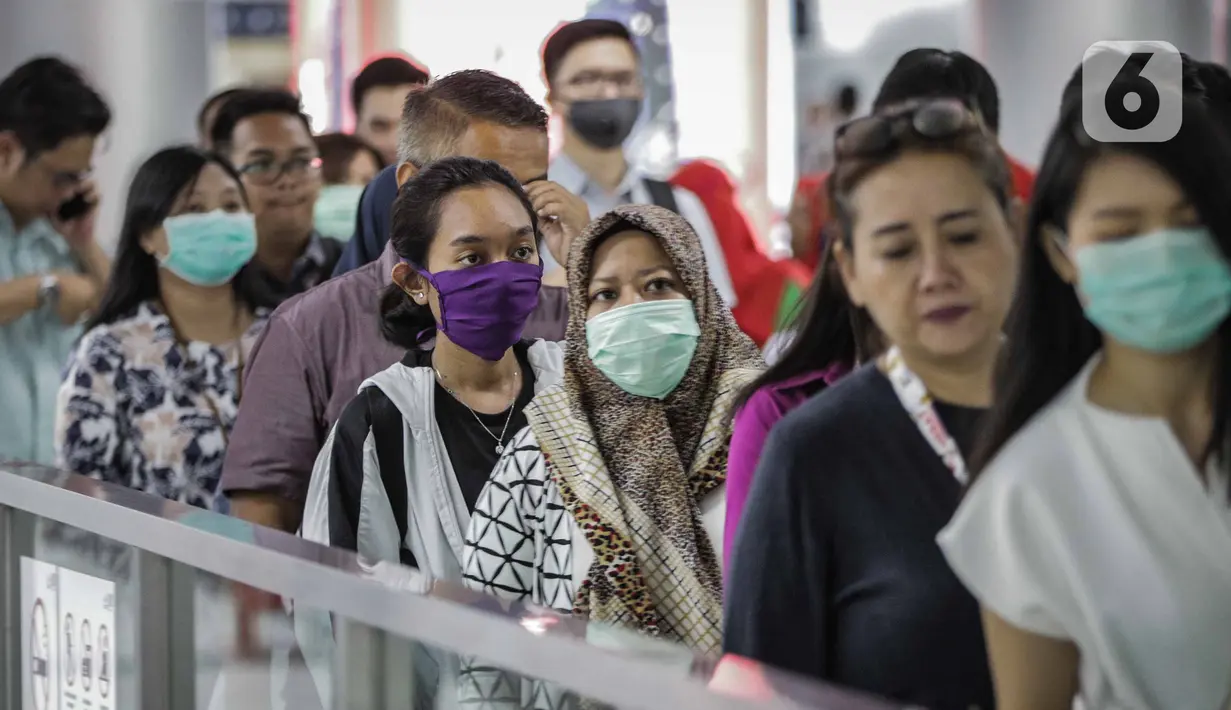Sejumlah penumpang menggunakan masker saat antre memasuki kereta Mass Rapid Transit (MRT) di Stasiun Bundaran HI Jakarta, Selasa (3/3/2020). Penumpang dengan gejala demam tinggi dilarang masuk dan menggunakan MRT sebagai upaya pencegahan penyebaran virus corona Covid 19. (Liputan6.com/Faizal Fanani)