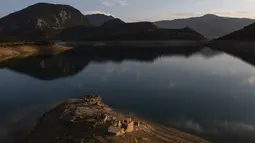 Reruntuhan desa Kallio muncul kembali dari Danau buatan Mornos, sebuah waduk di Yunani, akibat suhu yang memecahkan rekor dan kekeringan berkepanjangan di wilayah tersebut. (Angelos TZORTZINIS / AFP)