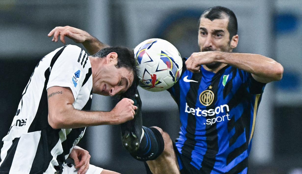 Pemain Inter Milan, Henrikh Mkhitaryan, berebut bola dengan pemain Juventus, Andrea Cambiaso, pada laga Liga Italia di Stadion Giuseppe Meazza, Minggu (27/10/2024). (AFP/Gabriel Bouys)