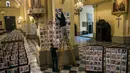 Pekerja menempelkan potret korban meninggal akibat virus corona di dalam Katedral, di Lima, Peru pada 13 Juni 2020. Misa Minggu di Katedral Lima dihadiri lebih dari 4.000 potret mereka yang telah meninggal dalam pandemi Covid-19 yang menyebar di Peru. (AP Photo/Rodrigo Abd)