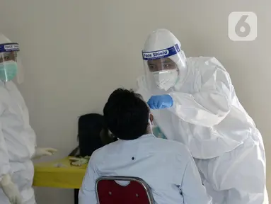 Petugas Puskesmas melakukan swab test terhadap warga di Balai RW 20, Villa Dago, Pamulang, Tangerang Selatan, Banten, Jumat (17/7/2020). Swab test gratis yang dilakukan seiring meningkatnya kasus COVID-19 tersebut diikuti 200 warga dari beberapa RW di Benda Baru. (merdeka.com/Dwi Narwoko)