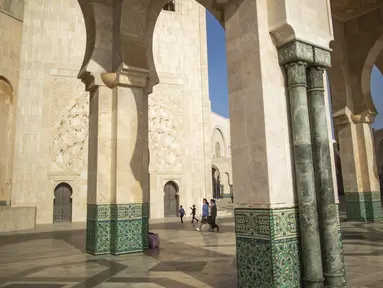 Turis berjalan di dalam masjid Hassan II, salah satu yang terbesar di Afrika, di Casablanca, Maroko (7/2/2020). Masjid ini mulai dibangun tahun 1980, didesain oleh arsitek berkebangsaan Prancis Michel Pinseau dan dibangun oleh Bouygues. (AP Photo/Mosaab Elshamy)