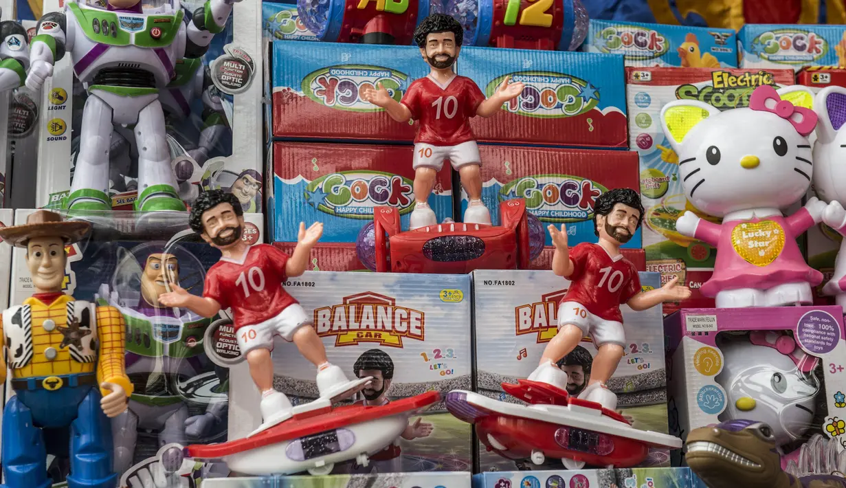 Mainan anak bertema Mohamed Salah terpajang di salah satu toko di Kairo, Mesir, Senin (30/5/2018). Menjadi pahlawan baru bagi rakyat Mesir, pernak pernik Mohamad Salah laris manis. (AFP/Khaled Desouki)