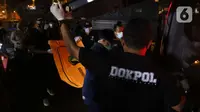 Tim DVI Polri membawa kantong jenazah yang diduga berisi bagian tubuh penumpang pesawat Sriwijaya Air SJ 182 di Dermaga JICT 2, Jakarta, Minggu (10/1/2021) dini hari. Sriwijaya Air SJ 182 membawa 62 penumpang dan kru. (Liputan6.com/Helmi Fithriansyah)