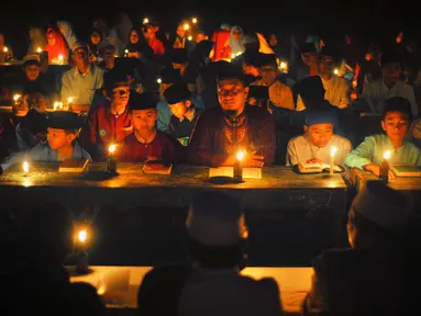 Santri dari Pondok Pesantren Nurul Hidayah melakukan tadarus alquran dengan penerangan obor di tengah sawah Dusun Tempel, Desa Sempu, Kecamatan Andong, Kabupaten Boyolali, Selasa ( 21/5/2019). Pengajian tersebut untuk menyambut malam Nuzulul Quran pada 17 Ramadan 1440 Hijriah. (Liputan6.com/Gholib)