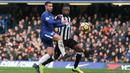Bek tengah Newcastle Bekel Mbemba berusaha menahan Eden Hazard saat melawan Chelsea di pertandingan Liga Inggris di Stamford Bridge, London (2/12). (AFP Photo/Daniel Leal-Olivas)