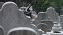 Seorang wanita mengunjungi makam kerabat saat Festival Chung Yeung atau juga dikenal Tomb Sweeping Day di sebuah pemakaman di Hong Kong, 17 Oktober 2018. Festival ini adalah hari untuk menghormati dan mengingat leluhur keluarga.  (Anthony WALLACE/AFP).