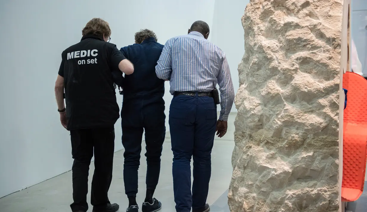 Abraham Poincheval langsung dibawa ke rumah sakit usai dikeluarkan dari dalam sebuah batu di Museum Paris, Prancis, Rabu (1/3). Ia berhasil menuntaskan tantangan tinggal seminggu dalam batu dan keluar dalam keadaan lemah. (AP Photo/Zacharie Scheurer)