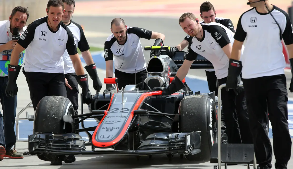 Tim Mekanik McLaren sedang mempersiapkan mobil Jenson Button untuk mengikuti latihan bebas pertama di Sirkuit Internasional Bahrain, Jumat (17/4/2015). (AP Photo/Kamran Jebreili)