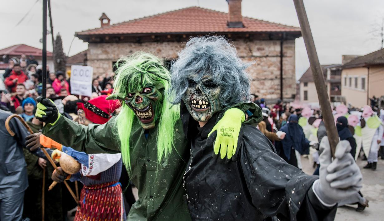 Dua orang peserta mengenakan kostum setan saat mengikuti karnaval di desa Vevcani, Macedonia (13/1). Karnaval Vevcani menandai dimulainya Tahun Baru sesuai dengan kalender Julian yang dianut oleh Gereja Orthodok Macedonia. (AFP Photo/Robert Atanasovski)