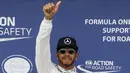 Pembalap Mercedes F1 Lewis Hamilton memberikan acungan jempol setelah kualifikasi di Australian Formula One Grand Prix di Melbourne (19/3). Juara F1 musim lalu itu mencatatkan waktu 1 menit 23,837 detik. (REUTERS/Brandon Malone)